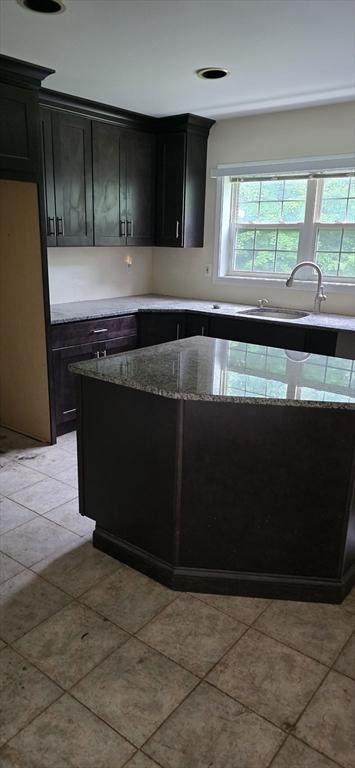 75 Downey Rd, North Brookfield, MA 01535 - kitchen with light stone counters, light tile patterned floors, and dark cabinetry