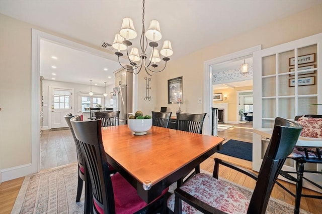 dining space featuring an inviting chandelier and light wood-type flooring