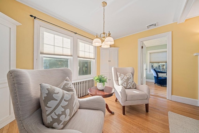 sitting room featuring crown molding and light wood-type flooring