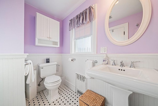 bathroom featuring tile patterned flooring, sink, radiator, and toilet