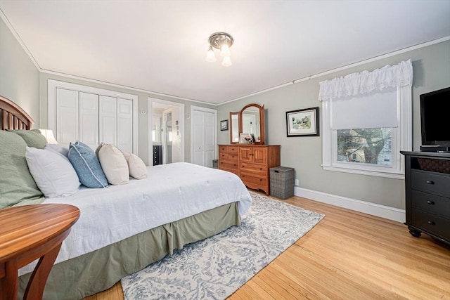 bedroom featuring ornamental molding, light wood-type flooring, and a closet