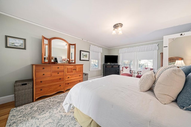 bedroom with hardwood / wood-style flooring and crown molding