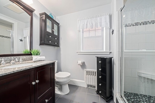 bathroom with tile patterned flooring, radiator heating unit, vanity, a shower with shower door, and toilet