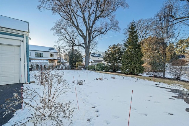 snowy yard with a garage