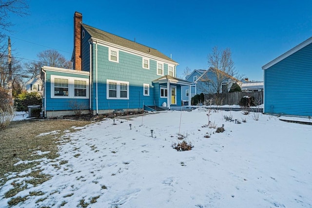 snow covered property featuring central AC