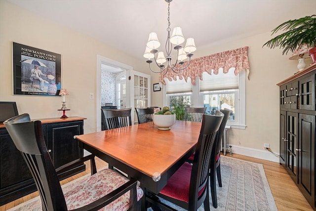 dining room with a notable chandelier and light wood-type flooring