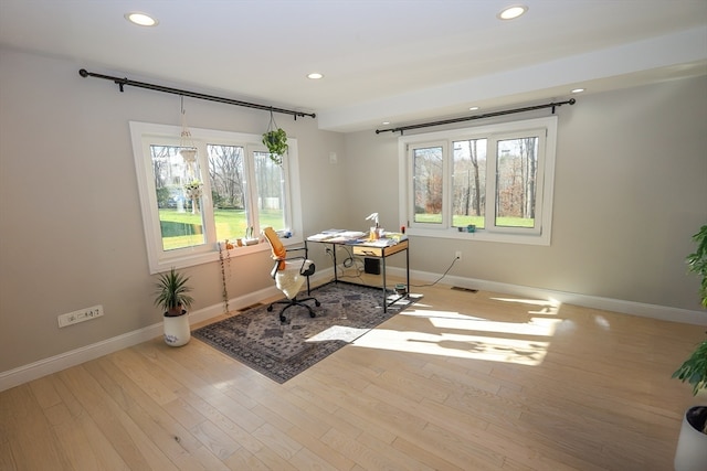 office space with a healthy amount of sunlight and light hardwood / wood-style flooring