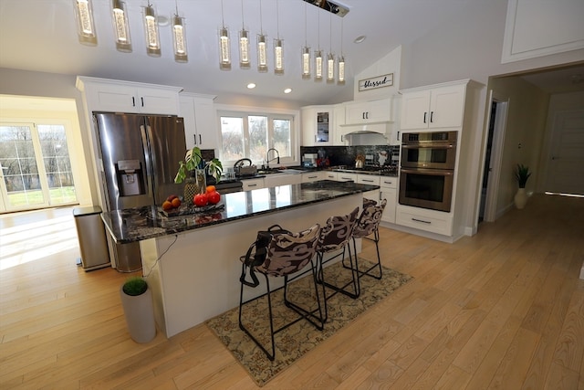 kitchen with pendant lighting, a center island, high vaulted ceiling, a kitchen breakfast bar, and stainless steel appliances