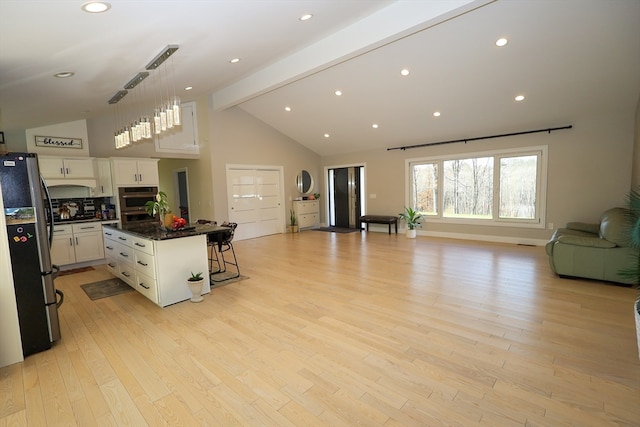 kitchen featuring a center island, a breakfast bar area, decorative light fixtures, white cabinetry, and stainless steel appliances