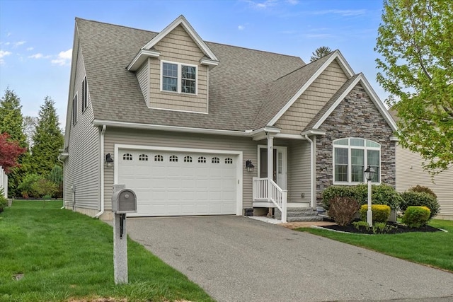 79 Empire Dr, North Andover, MA 01845 - view of front of house with asphalt driveway, a front yard, a shingled roof, an attached garage, and stone siding