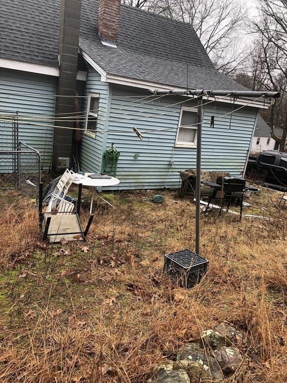 266 Pleasant St, Franklin, MA 02038 - rear view of house featuring a shingled roof and a chimney