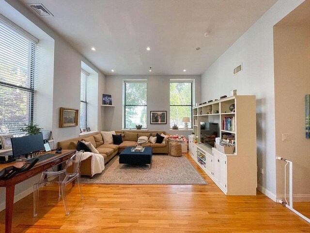 living area with light wood-style floors, recessed lighting, and baseboards