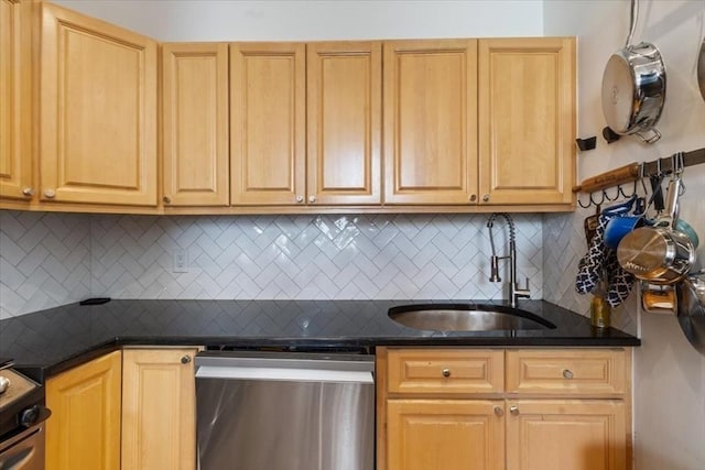 kitchen featuring appliances with stainless steel finishes, a sink, decorative backsplash, and light brown cabinets