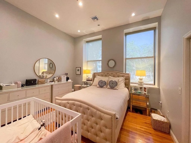 bedroom featuring light wood finished floors, recessed lighting, and baseboards