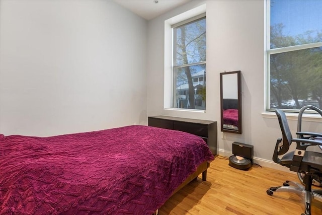 bedroom with wood finished floors and baseboards