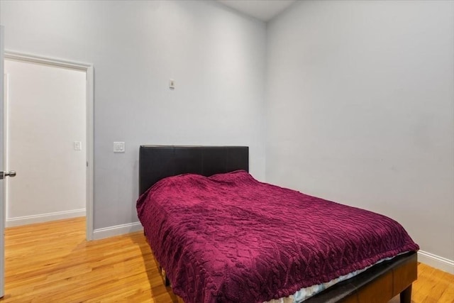 bedroom with light wood-style flooring and baseboards
