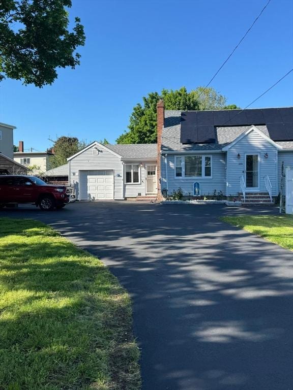 335 Euclid Ave, Lynn, MA 01904 - view of front of house featuring a chimney, solar panels, a garage, and driveway