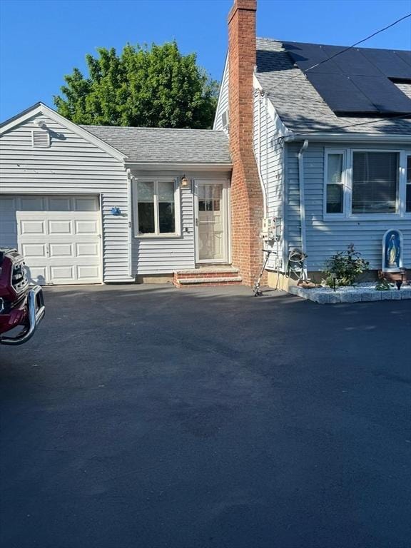 335 Euclid Ave, Lynn, MA 01904 - view of front of house with a chimney, an attached garage, driveway, and a shingled roof