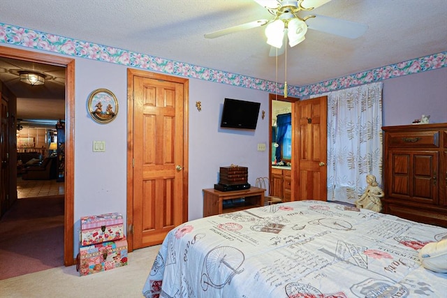 carpeted bedroom with ceiling fan and a textured ceiling