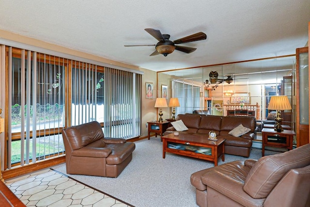 carpeted living area featuring a ceiling fan and a textured ceiling