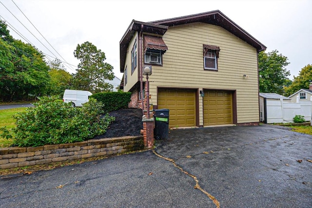 view of side of property featuring a garage and driveway