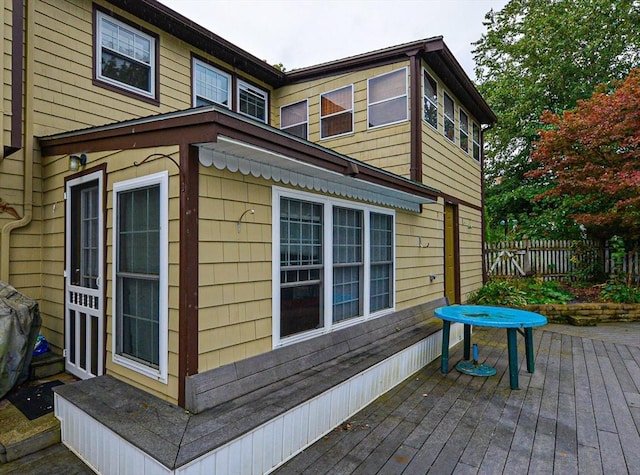 view of side of home with a wooden deck and fence