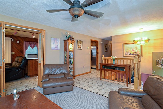 living area with a chandelier, a ceiling fan, and baseboards