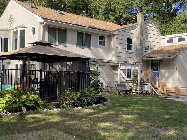 rear view of property featuring a gazebo and a yard