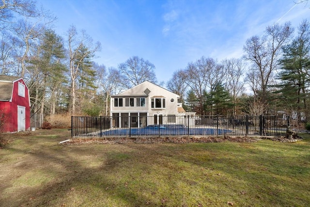 back of house featuring a yard and a covered pool