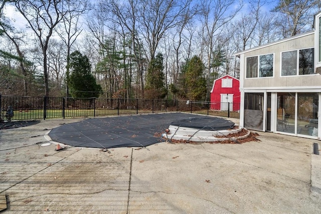 view of swimming pool featuring a patio area and a shed