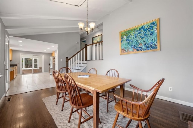 dining space with lofted ceiling with beams, wood-type flooring, and an inviting chandelier