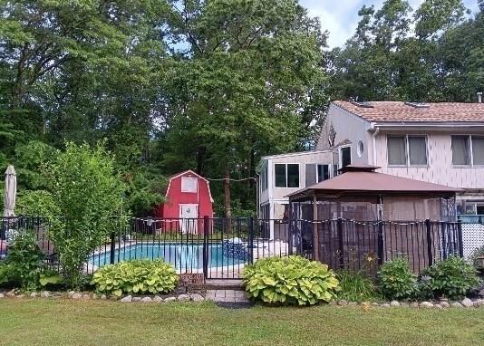 view of yard with a fenced in pool and a storage unit