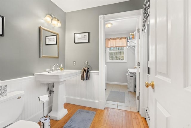 bathroom featuring hardwood / wood-style floors, a baseboard radiator, and toilet