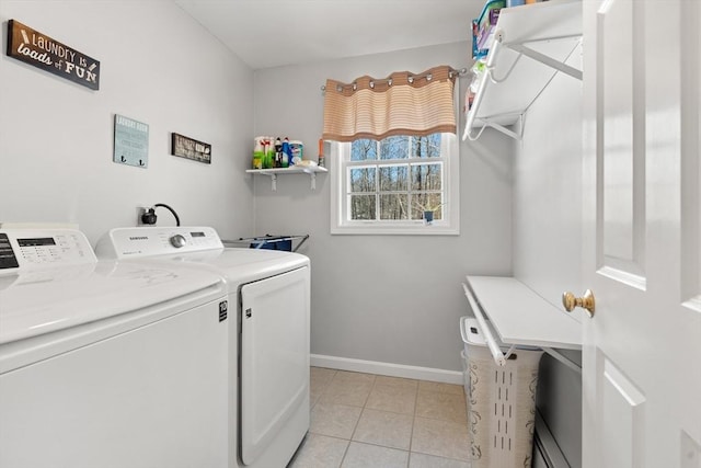 laundry area with washing machine and dryer and light tile patterned floors