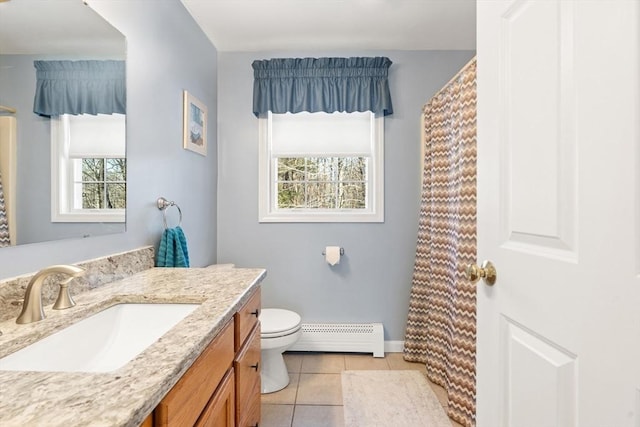 bathroom with toilet, vanity, tile patterned floors, and baseboard heating