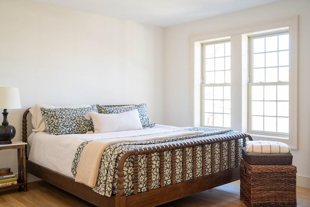 bedroom featuring multiple windows and wood finished floors