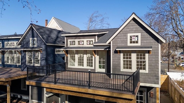 rear view of property with roof with shingles and a wooden deck