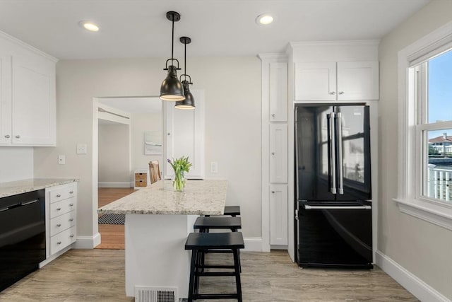 kitchen with black appliances, white cabinetry, plenty of natural light, light wood finished floors, and recessed lighting