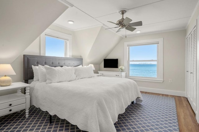 bedroom featuring a ceiling fan, wood finished floors, baseboards, ornamental molding, and lofted ceiling