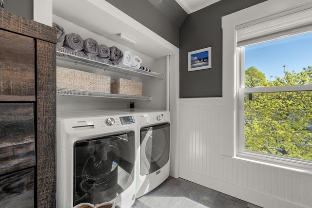 washroom featuring washing machine and clothes dryer, wainscoting, and crown molding