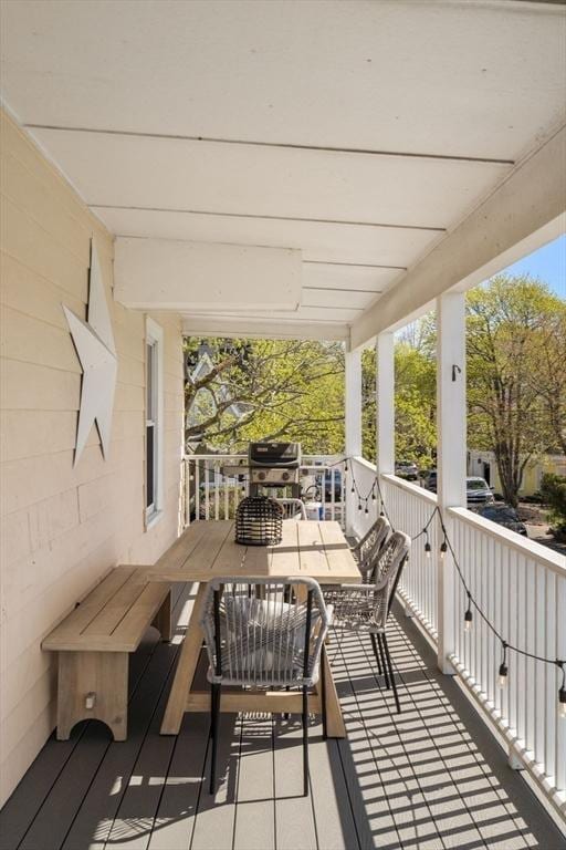 wooden deck with outdoor dining space and grilling area