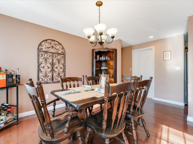 dining room featuring recessed lighting, baseboards, an inviting chandelier, and wood finished floors