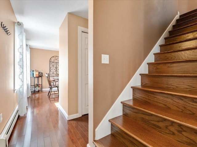 stairway featuring hardwood / wood-style flooring, baseboards, and baseboard heating