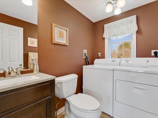 bathroom with washer and dryer, toilet, and vanity