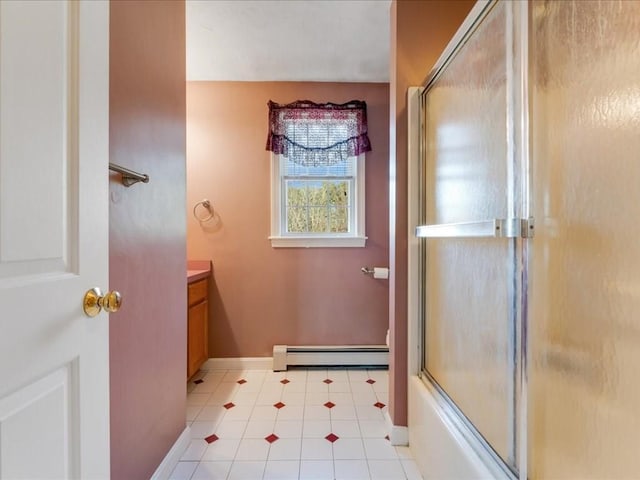 bathroom featuring a baseboard heating unit, enclosed tub / shower combo, tile patterned flooring, baseboards, and vanity