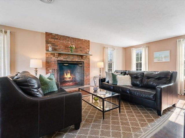 living area featuring a brick fireplace and wood finished floors