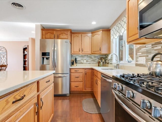 kitchen with light countertops, dark wood-style floors, visible vents, and appliances with stainless steel finishes