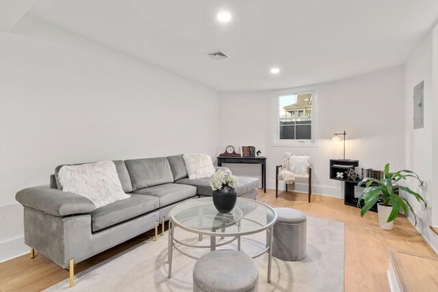 living area featuring electric panel, visible vents, light wood-style flooring, and recessed lighting