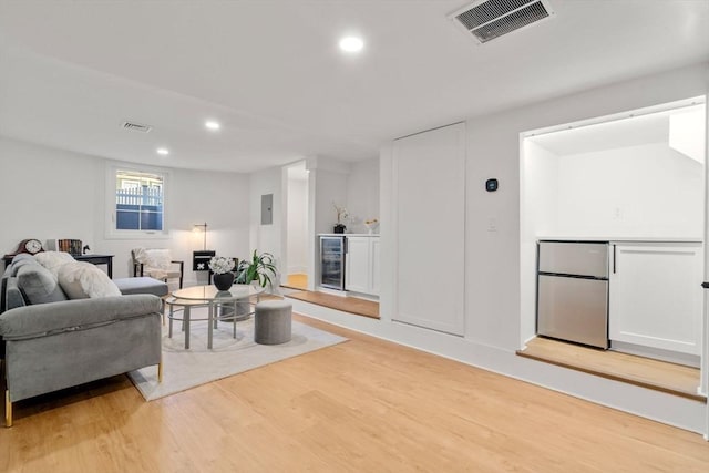 living room featuring recessed lighting, visible vents, beverage cooler, and light wood-style flooring