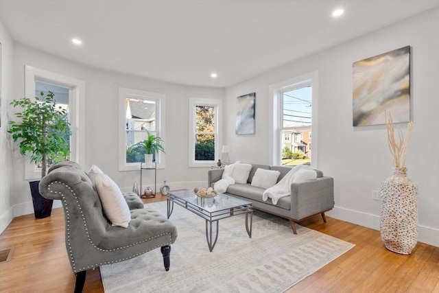 living area featuring recessed lighting, baseboards, and light wood-style floors